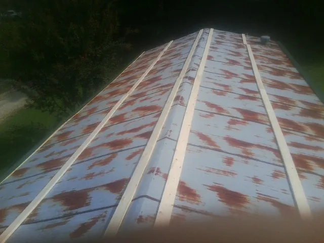 Rusted metal roof panels with new wood purlins before replacement — Storm Damage Roof Repair in New Deal by Roofing Brothers