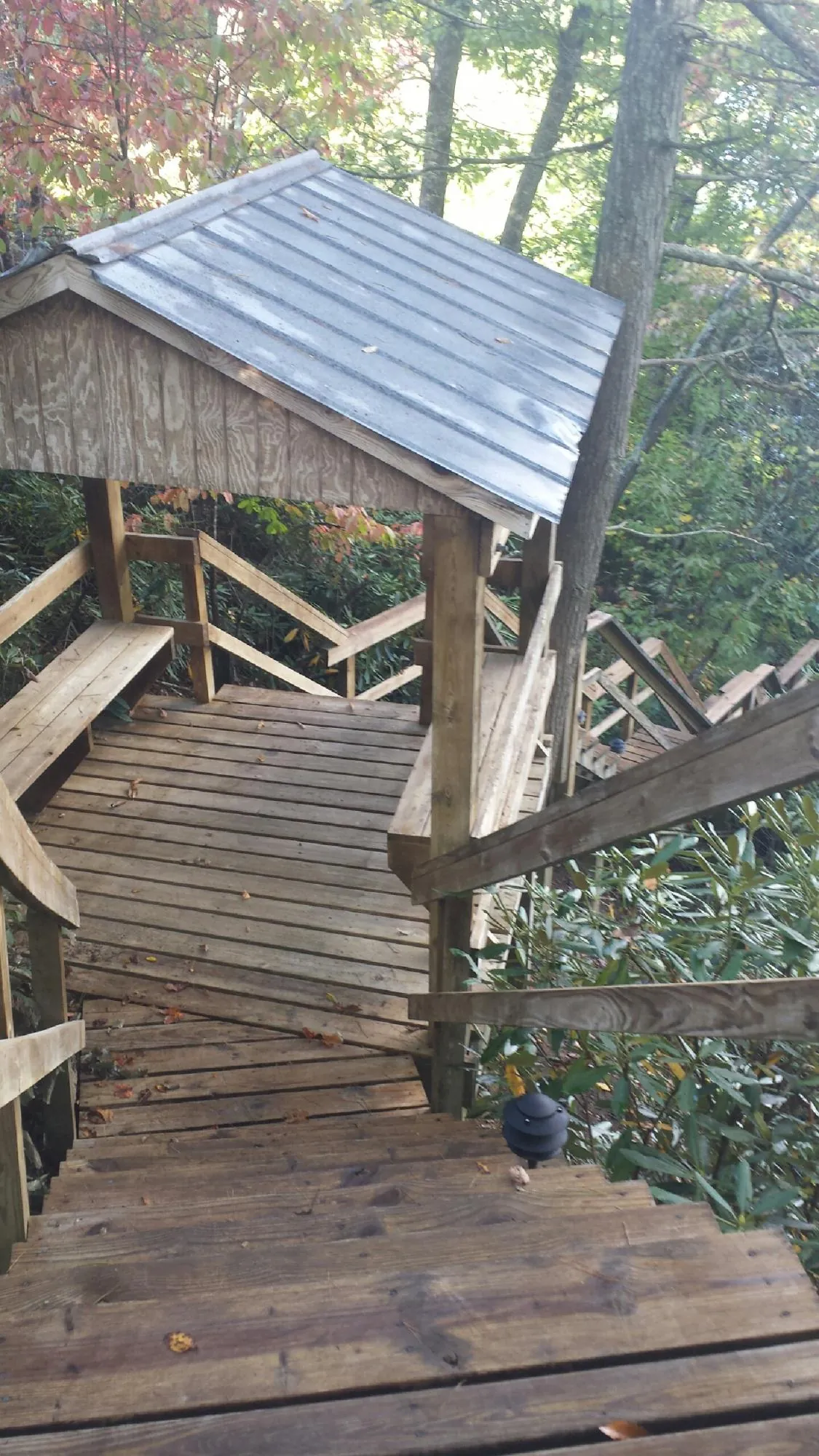 Metal roofed shelter over wooden steps on a wooded walkway — Skylight Repair & Installation work by our crew in New Deal