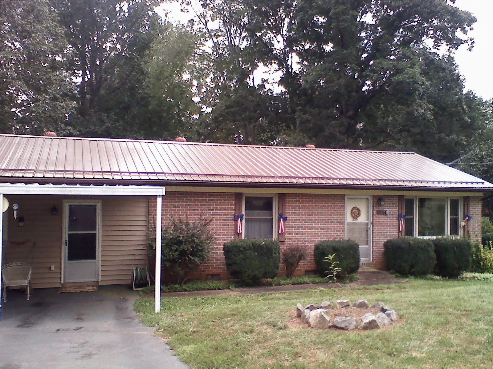 Bronze metal roof and carport on a brick ranch home — Roof Repair work by our crew in New Deal